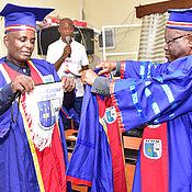 Delivery of the university insignia for Gerhard Bringmann by the Rector, A. Mpoyi (right), to the Secrétaire Général Académique, G.O. Lutumba. (Photo: A. Mfwamba)
