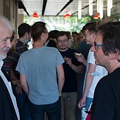 [Translate to Englisch:] Angeregte Diskussion zwischen Physikern (Prof. Eberhard Umbach und Prof. Jens Pflaum) während andere fränkische Spezialitäten genießen (Foto: C. Stadler)