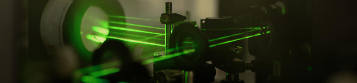 Green laser beams. Photo of a prism copressor.