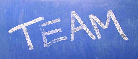 The word TEAM on a blue board