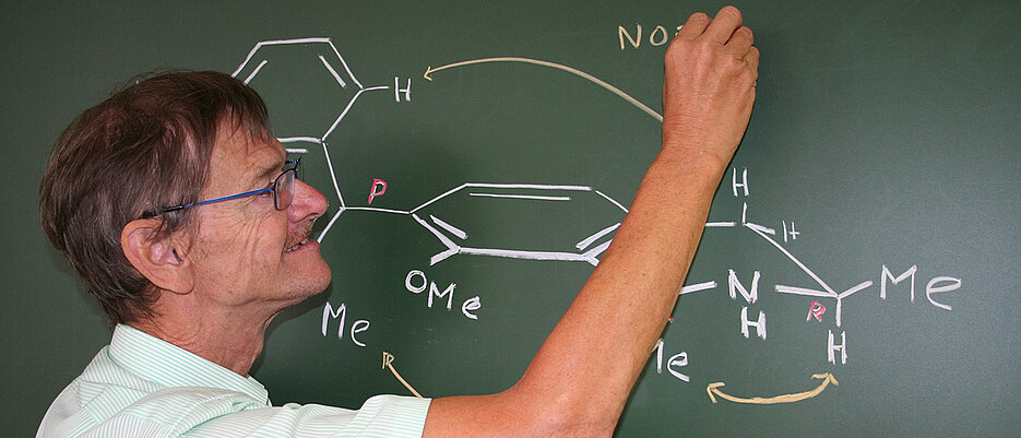 Gerhard Bringmann beim Zeichnen komplizierter chmischer Formeln