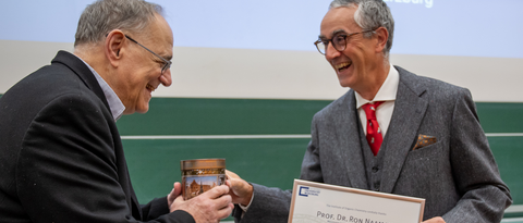 Laughter and happiness on receiving the certificate and typical franconian gingerbread: Prof. Ron Naaman (l.) and Prof. Christoph Lambert (Picture: C. Stadler)