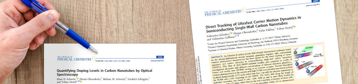 Two scientific articles of the Hertel group on a desk.