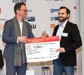 Juror Dr. Jörg Liebe von Lufthansa Systems beglückwünscht Matthias Kastner (r.) zum ersten Platz im Wettbewerb um den Univention-Absolventenpreis 2016. (Foto: Univention GmbH)