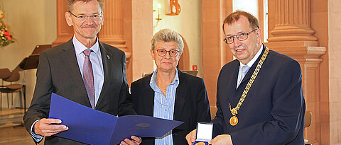 Nach der Verleihung der Verdienstmedaille: Gerhard Bringmann mit Laudatorin Univizepräsidentin Ulrike Holzgrabe und Unipräsident Alfred Forchel (r.)