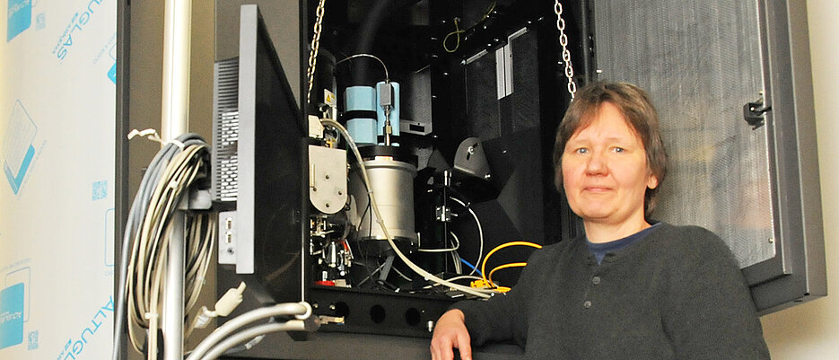Prof. Dr. Bettina Böttcher in front of Titan Krios, one of the world's most powerful electron microscopes (photo: Gunnar Bartsch)