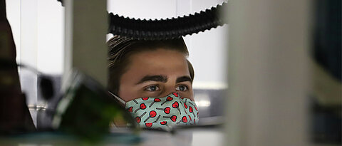 A PhD student, lurking over a shelf in the laser lab.